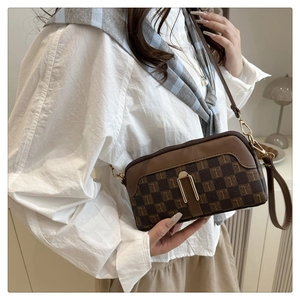 Détail du sac bandoulière vintage avec motif à carreaux marron et boucle dorée en forme de U