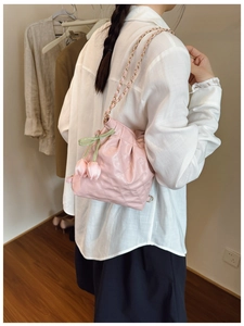 Detailed side view of pink quilted cloud bag with tulip charms and chain strap