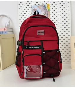 Détail du sac à dos rouge imperméable montrant plusieurs zips et poches latérales en filet