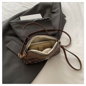 Vue macro de l'intérieur d'un sac bandoulière marron montrant le rangement du mobile