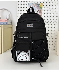 Détail du sac à dos en nylon noir avec peluche panda et boucles de compression latérales