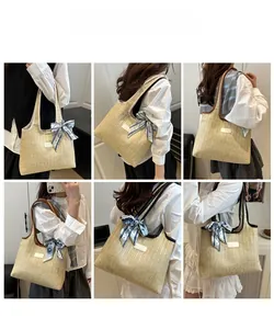 Detail of woven straw tote bag with PU straps and decorative geometric print scarf accessory