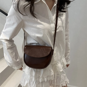 Minimalist dark brown saddle bag with retro semi-circular flap design and shoulder strap