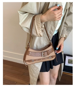 Detail of vintage woven shoulder bag with brown leather straps and silver metal eyelets