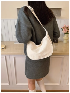 Detailed view of beige hobo bag texture and silver buckle on adjustable shoulder strap