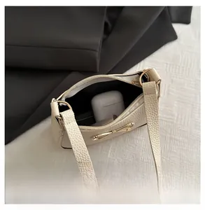 Detail view of the cream leather handbag interior with golden bow and zipper pocket