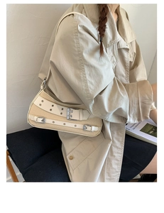 Detail shot of vintage canvas saddle bag with buckle straps worn by a model