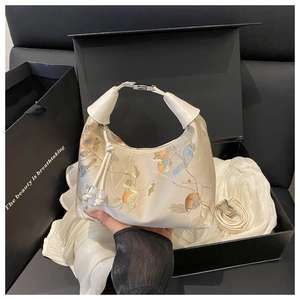 Detail of cream silk shoulder bag with exquisite flower and bird embroidery in gift box