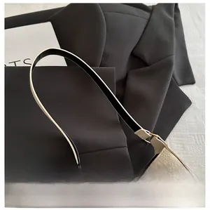 Detailed macro of beige lychee leather bag with elegant gold bow metal hardware buckle