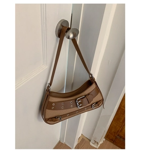 Detail view of a vintage canvas and leather hobo bag with wide buckle and silver hardware
