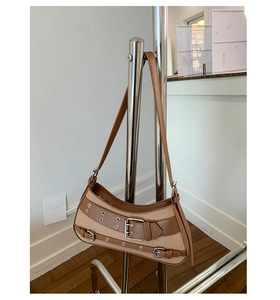 Detail showing vintage saddle bag with khaki canvas, brown leather straps, and metal rivets