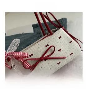 Detail showing red leather bow and lace ribbon on polka dot handbag for women