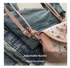 Détail du sac rose montrant la boucle argentée réglable sur la fine bandoulière en cuir