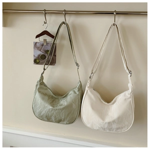 Detail of sage green and beige crescent bags with waterproof nylon texture