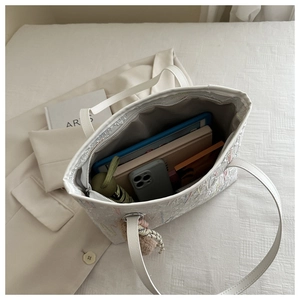 Interior view of large white tote bag with embroidery, showing spacious storage capacity