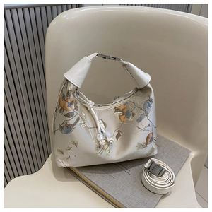 Detailed view of beige embroidery handbag with floral patterns and pearl drawstring