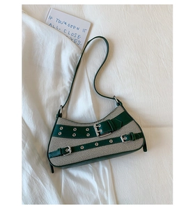 Detail of green and white striped canvas underarm bag with decorative leather buckle strap