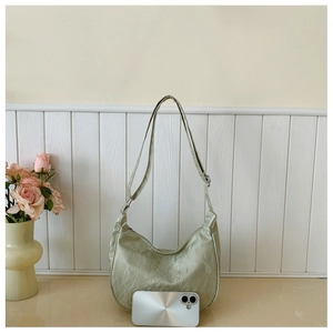 Size comparison of light green textured hobo bag shown with a large smartphone