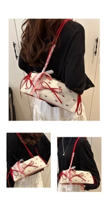 Detail of a sweet cream bag with red bows and white lace trim shown on a model