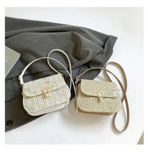 Detail of woven straw crossbody bags featuring floral embroidery and metal teardrop clasps