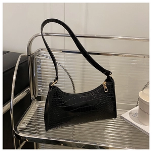 Close-up of black crocodile pattern baguette bag with premium gold metal hardware