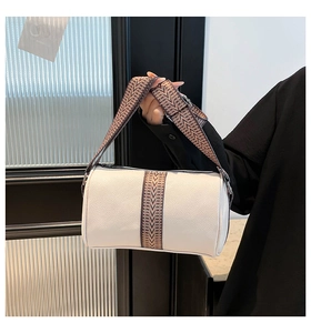 Close-up of white leather Boston bag with vintage patterned wide fabric shoulder strap