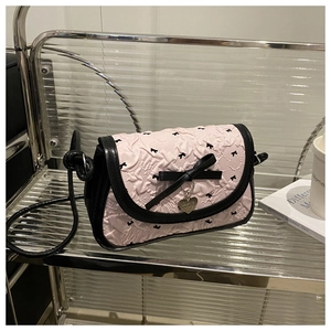 Gros plan détaillé sur le tissu gaufré rose et le pendentif en cœur d'un sac à bandoulière