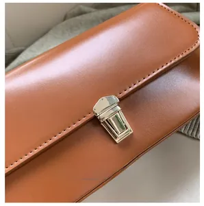 Vue macro de la boucle en métal et des coutures sur le sac baguette en cuir marron