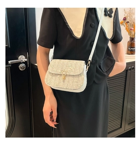 Detailed shot of white woven saddle bag with gold buckle and slim leather strap