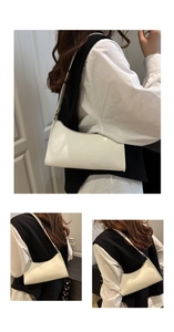 Detail view of glossy white patent leather shoulder bag with sleek rectangular shape