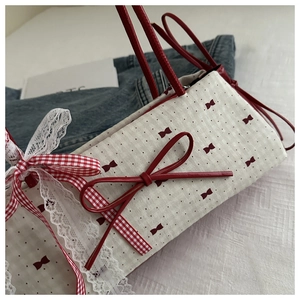 Détail du nœud rouge et du motif de ruban sur un sac à main en tissu blanc
