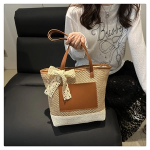 Détail du sac cabas en paille avec poche en cuir marron et nœud en dentelle crème