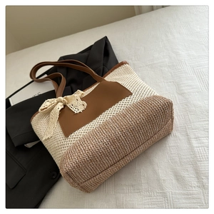 Detail of hand-woven tote bag with contrast stitching and delicate lace bow accent