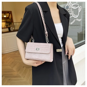 Detail of pink croc-embossed flap bag with silver chain strap and metal turn-lock