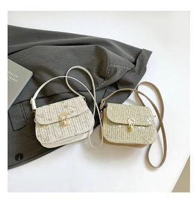Close-up of woven straw crossbody bags featuring floral embroidery and gold metal locks