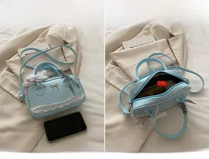 Macro shot of light blue lace crossbody bag with metal bow and inner compartment detail