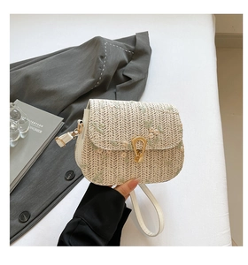 Détail d'un sac en paille tissé main avec broderies florales délicates et fermoir doré