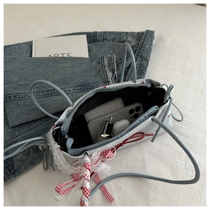 Détail de l'intérieur du sac sous l'aisselle à nœud bleu montrant le rangement interne