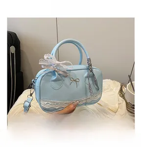 Close-up of light blue bag featuring metallic bow, lace trim, and checkered ribbon details
