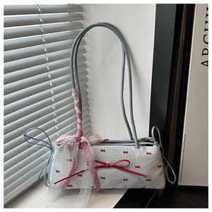Détail du sac à main bleu clair à nœuds avec motif rouge et ruban de dentelle décoratif