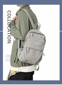 Gray nylon backpack with songuo embroidery on a model showing side view and texture