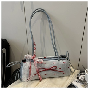 Gros plan du sac sous l'aisselle bleu clair avec nœuds rouges et dentelle fine