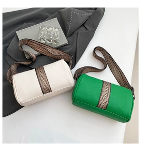 Detail of lychee pattern leather cylinder bags with ethnic woven straps in cream and green