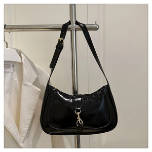Detailansicht der schwarzen Lackleder-Schultertasche mit edler goldener Metallschnalle