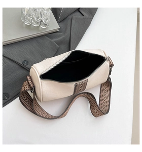 Top view of cream white cylinder bag featuring a textured leather finish and jacquard strap