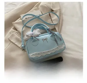 Detail of light blue bow bowling bag with lace trim shown next to a smartphone