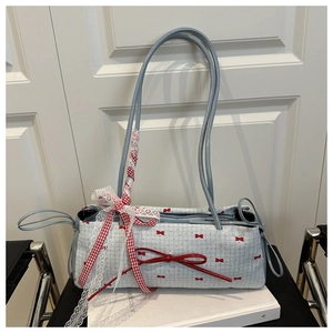 Détail du nœud rouge et dentelle sur le sac floral bleu clair pour femme