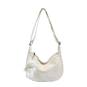 Chic beige dumpling crossbody bag with cute plush bear charm and adjustable shoulder strap