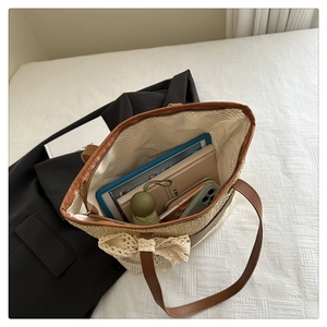 Detail of spacious straw tote bag interior showing capacity for tablets and daily essentials