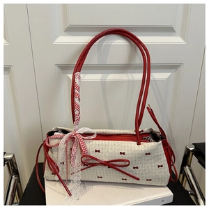 Détail du sac à main à carreaux blanc cassé avec nœuds rouges et ruban de dentelle